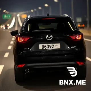 Rear angle close-up. Capturing the back of 2025 Mazda CX-5 2.5 2WD, Black, license plate 'BSQ 6882'. Behind it, a 2026 BYD Sealion 7 Performance, Cosmos Black with official Malaysia EV white license plate with 'ZEV' green logo, number 'ALN 9114'. Cruising at night on PLUS Highway towards Ipoh. The highway asphalt is absorbing the ambient light. Photorealistic, high resolution, car photography, bokeh background.